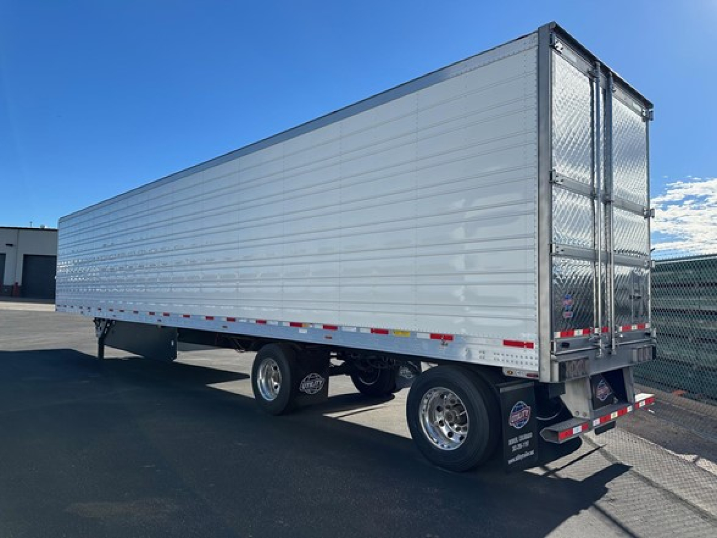 2026 Utility 3000R trailer side and rear view showing aluminum panel walls, dual rear doors, and tandem axles.