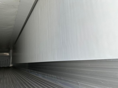 Trailer interior side wall and floor of a new Utility 3000R refrigerated trailer showing ribbed metal floor and smooth insulated wall.