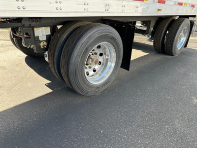 Utility 3000R trailer undercarriage showing dual tires on aluminum rims and undercarriage components.