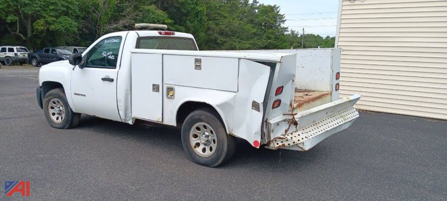 White Chevrolet Silverado 1500 utility/service bed truck with utility boxes on the side and a stepped rear bumper, 4wd, in-service condition.