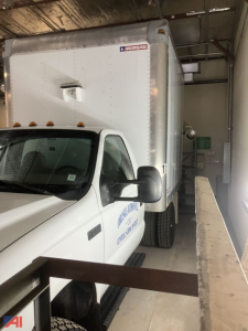 Ford F-550 box truck in a workshop showing cab and box trailer with MORSAN label on side.