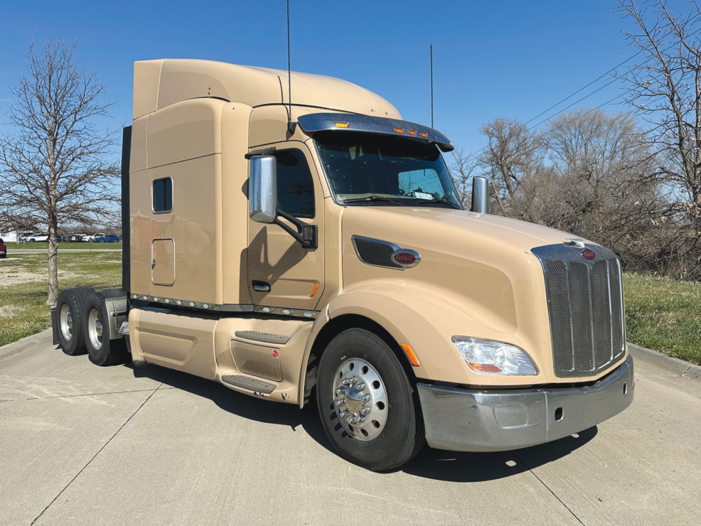 Peterbilt 579 UltraCab day cab tractor showing beige exterior, chrome grille, and side mirrors