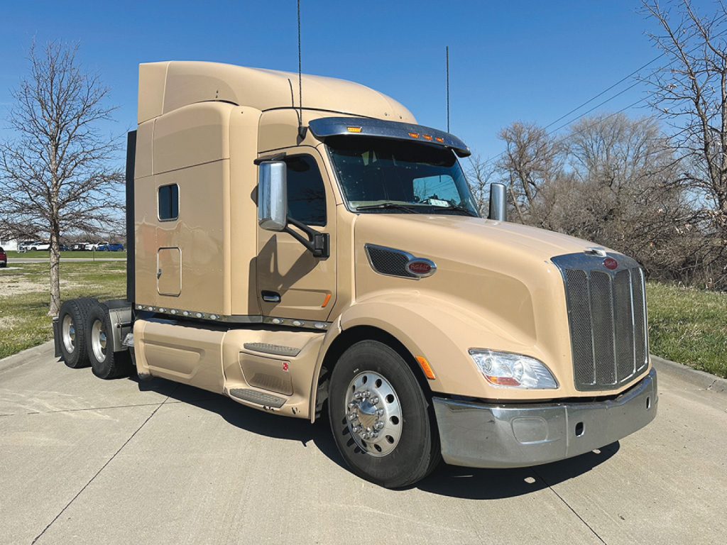Peterbilt 579 UltraCab day cab tractor showing beige exterior, chrome grille, and side mirrors