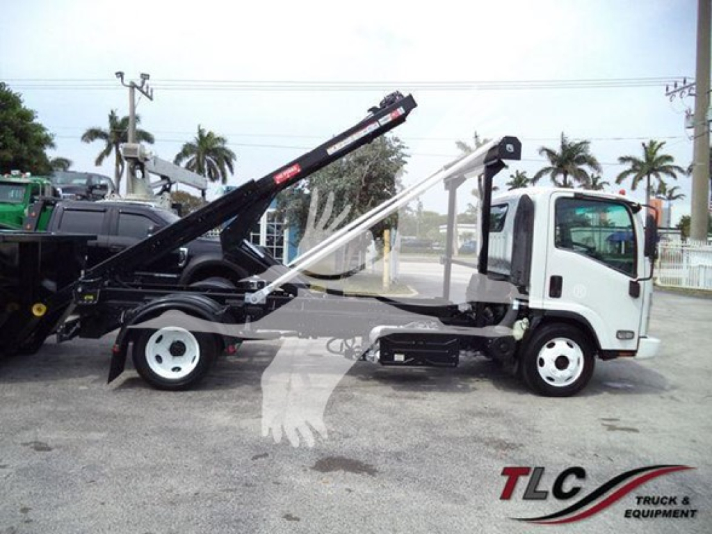 Isuzu NRR truck with roll-off hoist system side view showing hydraulic arms and controls.