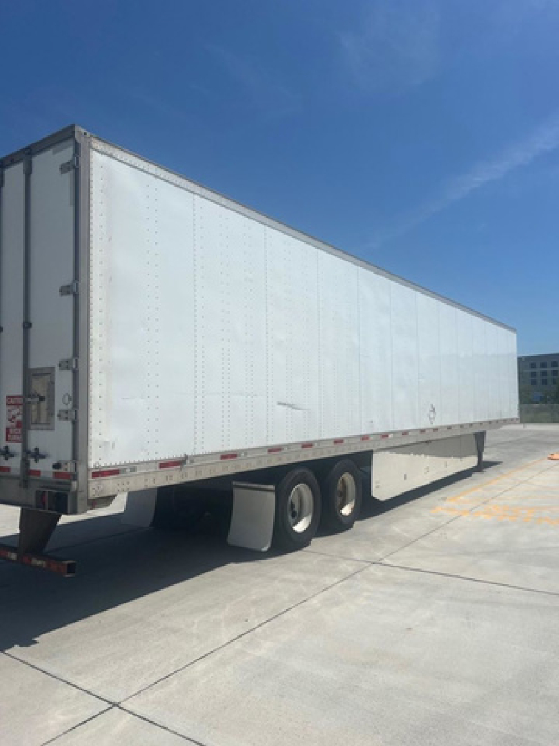 Trailer 2012 Utility Van viewed from rear left side showing white box trailer with dual rear wheels and reflective tape along sides.