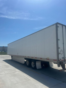 Utility van/trailer side view showing a large white box trailer with dual rear wheels undercarriage, no visible branding.