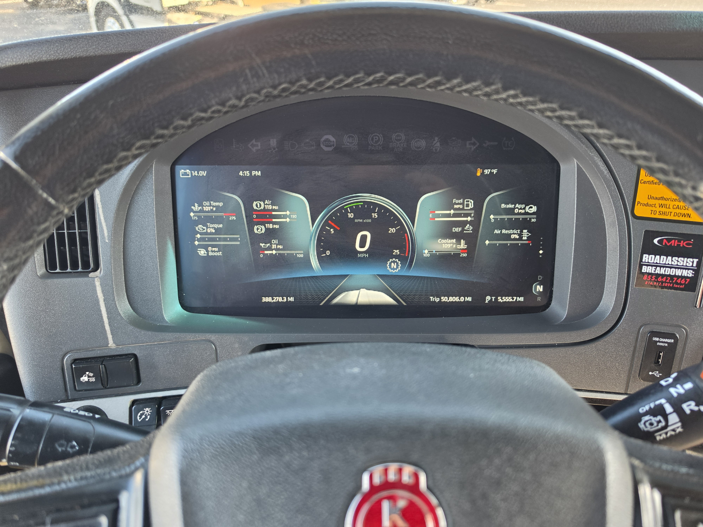 Dashboard of a 2023 Kenworth T680 showing digital instrument cluster with 0 mph, steering wheel, and driver’s view.