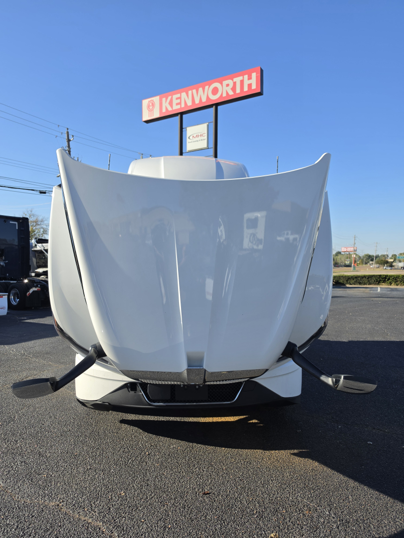 Kenworth T680 front view showing large hood with open hood vents and bumper, in a dealership lot.