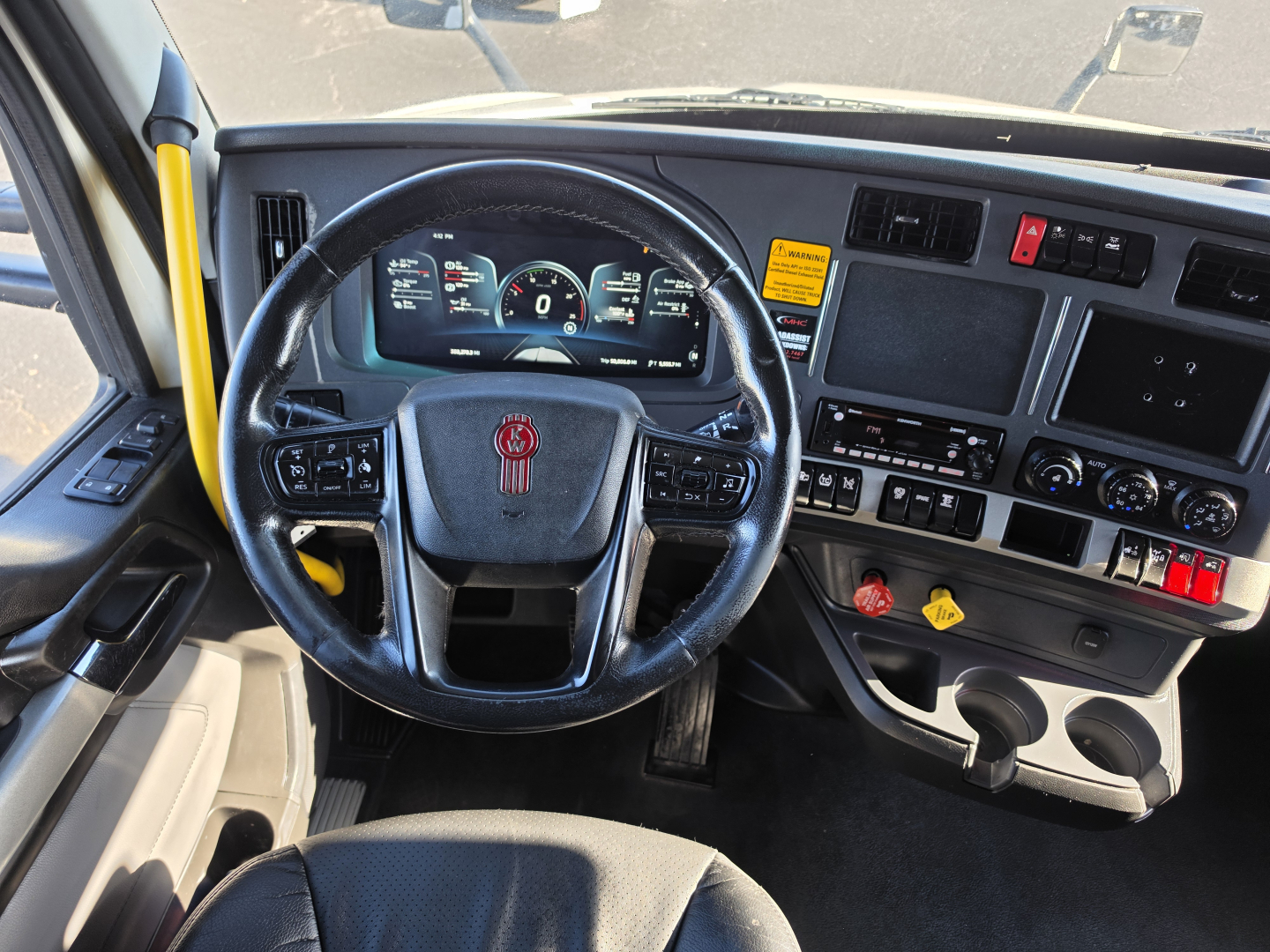 Kenworth T680 interior steering wheel and dashboard showing gauges and controls.