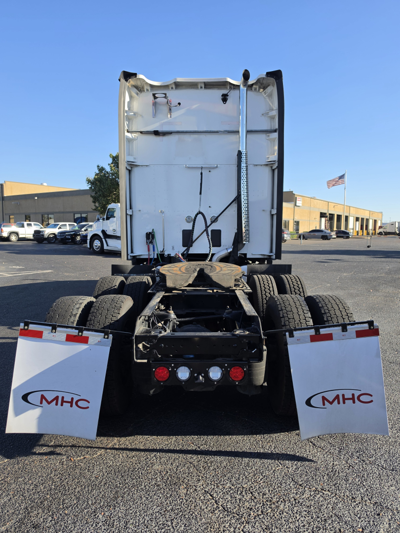 Truck rear view of a used 2023 Kenworth T680 with fifth-wheel area and mud flaps showing MHC branding, rear lights, and truck chassis.