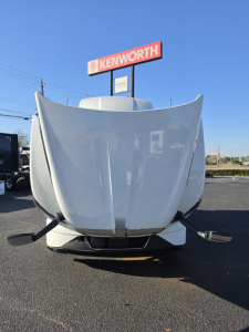 Kenworth T680 front view showing large hood with open hood vents and bumper, in a dealership lot.