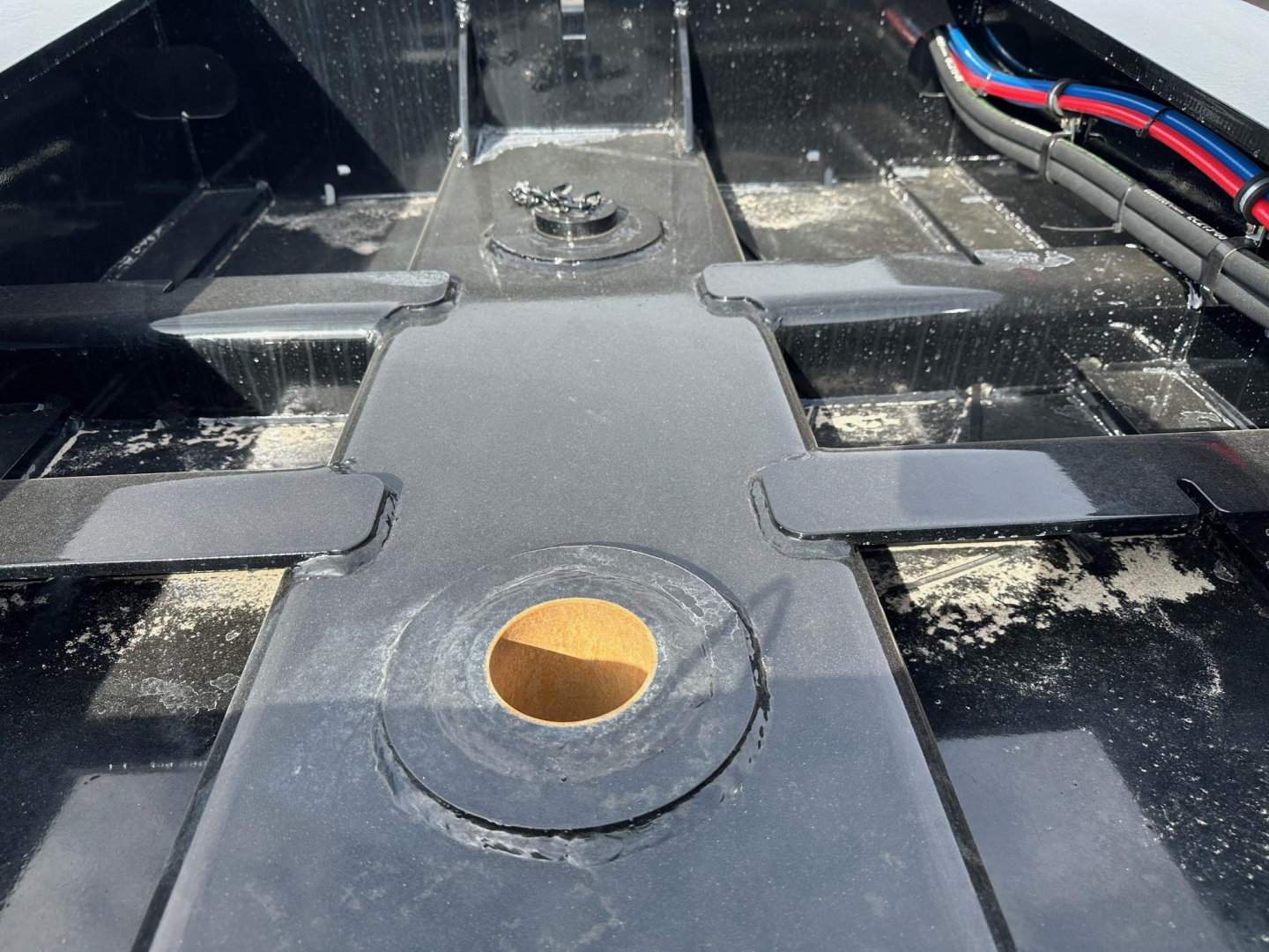 Load King 55 Ton Lowboy trailer hitch area showing central kingpin receptacle and surrounding frame components.
