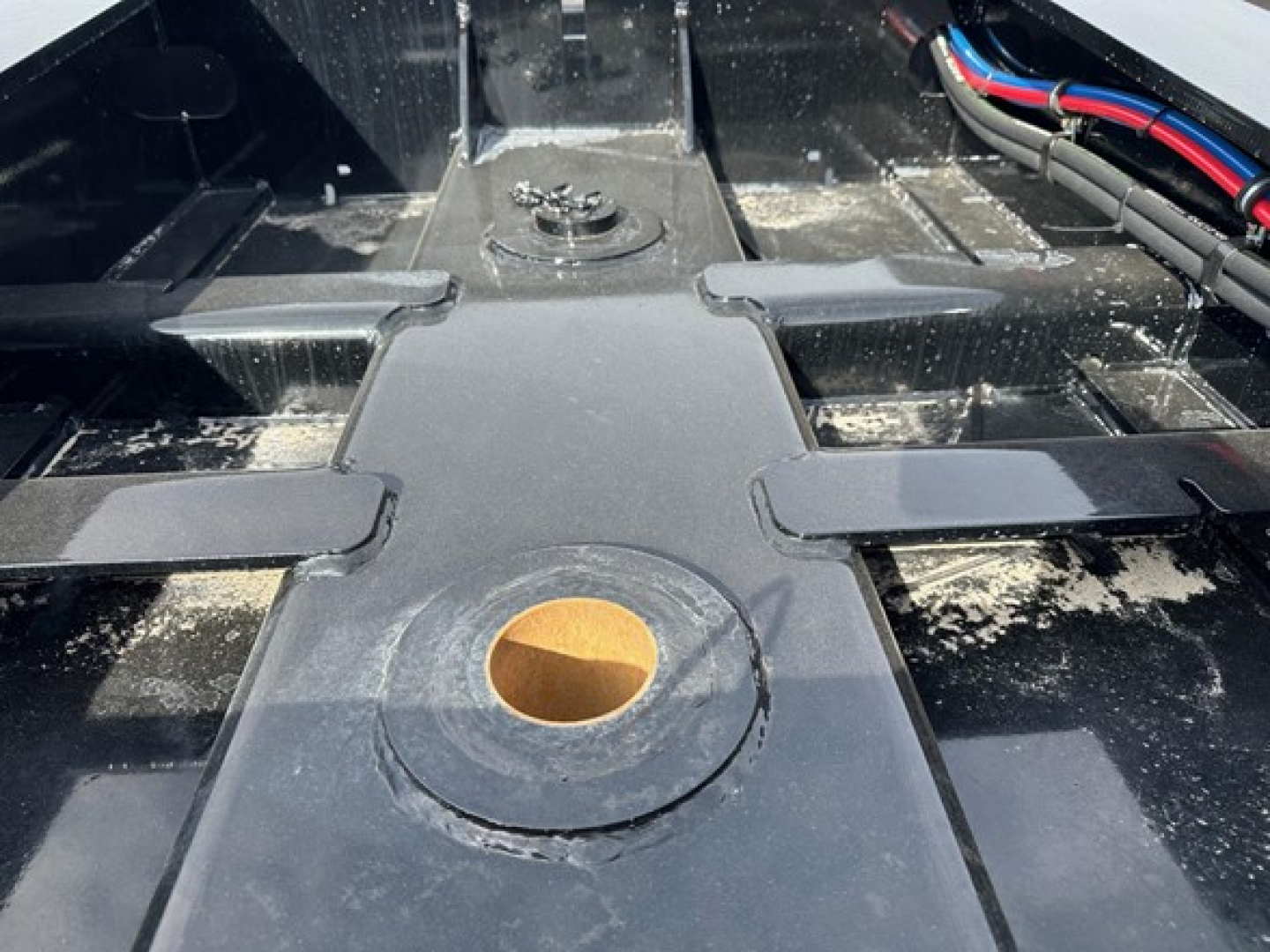 Load King lowboy trailer hitch area showing central kingpin mount and side rails.