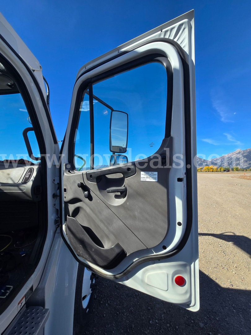 Door of Freightliner 2200SEB truck showing interior panel and window with mirror; exterior light gray door frame.