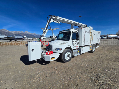 Freightliner 2200SEB utility truck with hydraulic crane, front-mounted control box, and service body, in a dirt lot.
