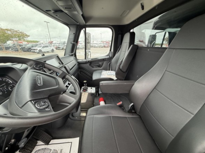 Cab interior of a 2026 Freightliner Business Class M2 106 truck showing driver seat with steering wheel, dashboard, and passenger seat.