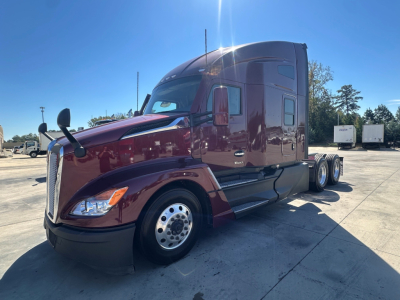 Kenworth T680 6x4 sleeper cab tractor in maroon with chrome wheels, side mirrors, and aerodynamic hood viewed from front-left.