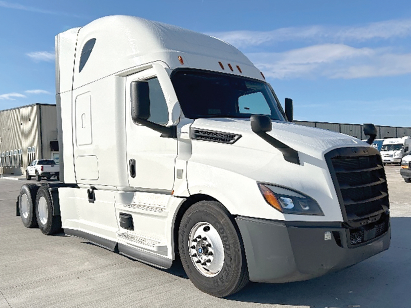 Truck cab of a white Freightliner Cascadia126 sleeper showing front grille and passenger side with VIN and stock info not visible.