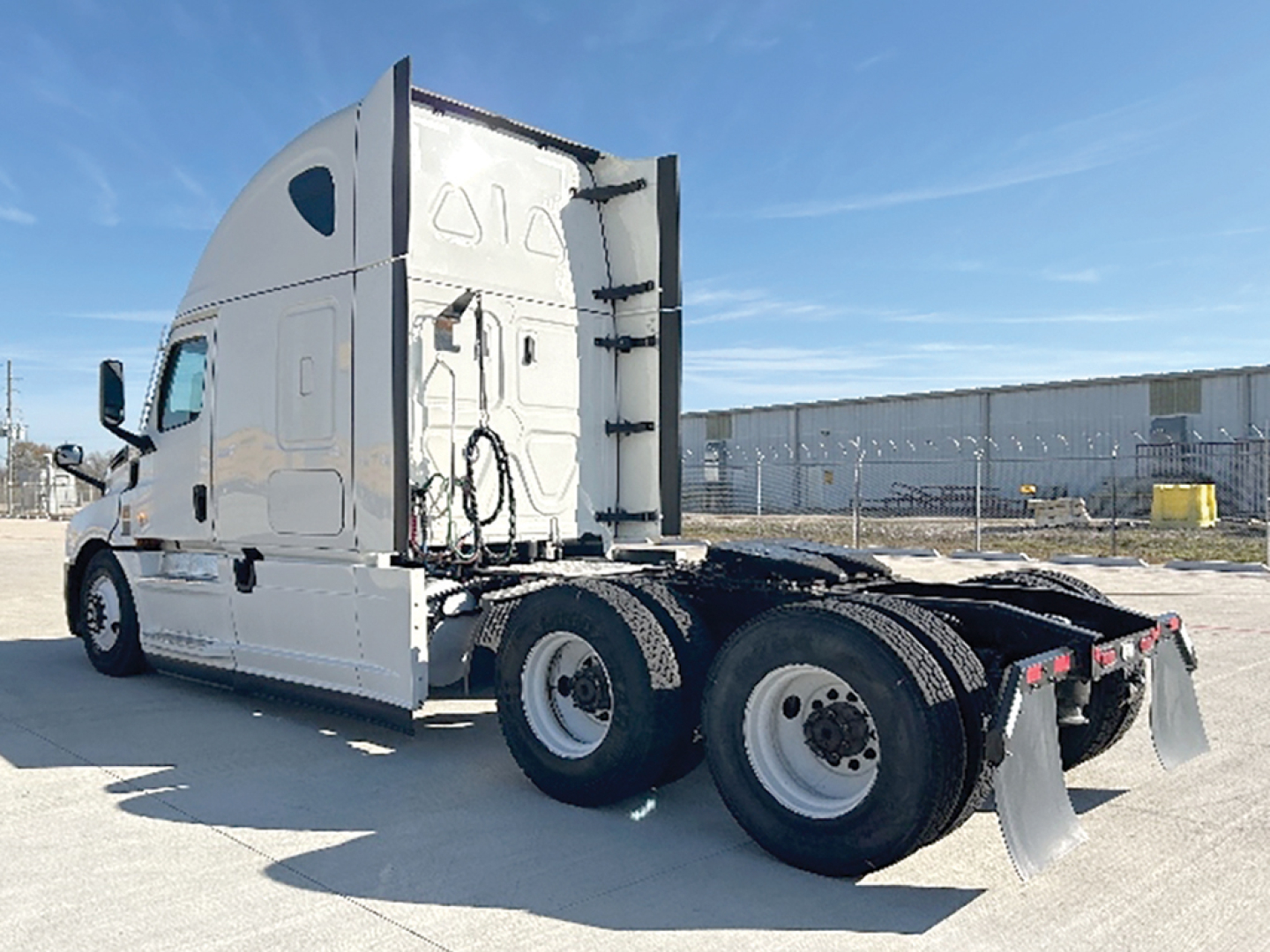 Truck rear/side view showing Freightliner Cascadia126 tractor with sleeper cab, dual rear axles, chassis, and fifth-wheel area.