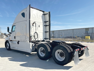 Truck rear/side view showing Freightliner Cascadia126 tractor with sleeper cab, dual rear axles, chassis, and fifth-wheel area.