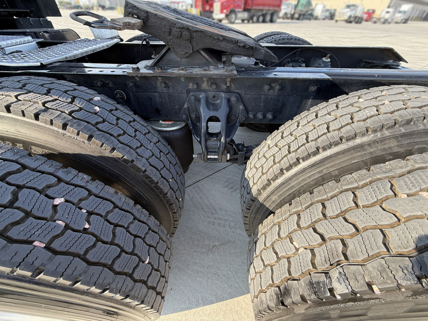 Kenworth T680 chassis with dual rear axles and fifth wheel coupling showing suspension and frame detail.