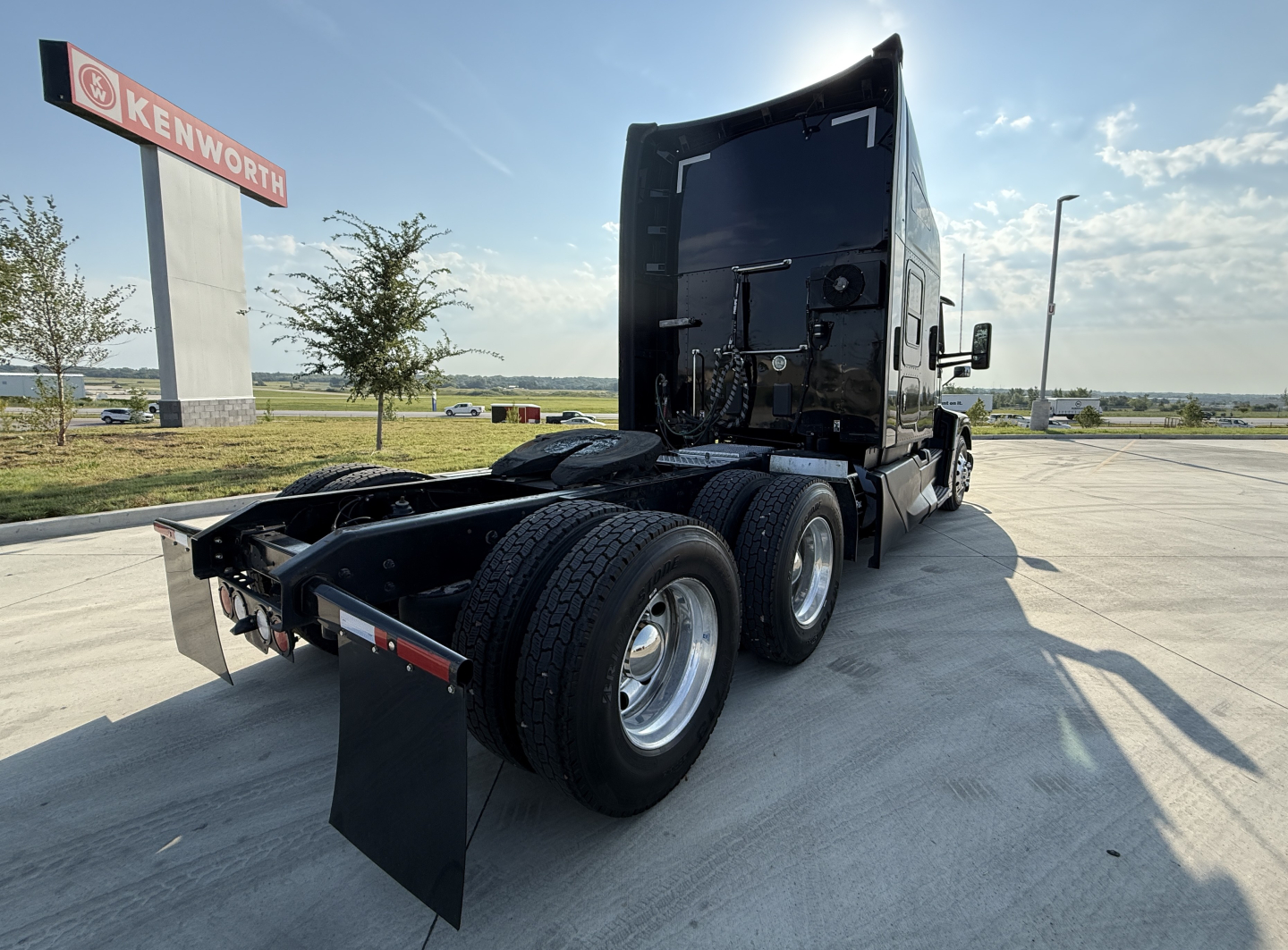 Kenworth truck chassis rear and sleeper cab view showing dual rear axles and fifth wheel mounting, with no visible text on components.