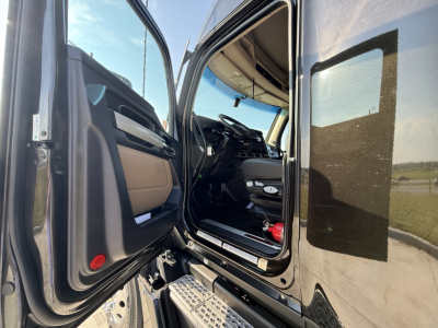 Kenworth T680 truck cab interior view from open door showing steering wheel, dashboard, and entry steps.