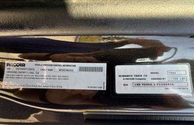 Label stickers on Kenworth T680 showing PACCAR Vehicle Emission Control Information and VIN/stock details. Visible text includes: VIN 1XKYD49X2PJ159416, model 680, chassis wt 17285 lb, ID 1XKYD49X-2-PJ159416.