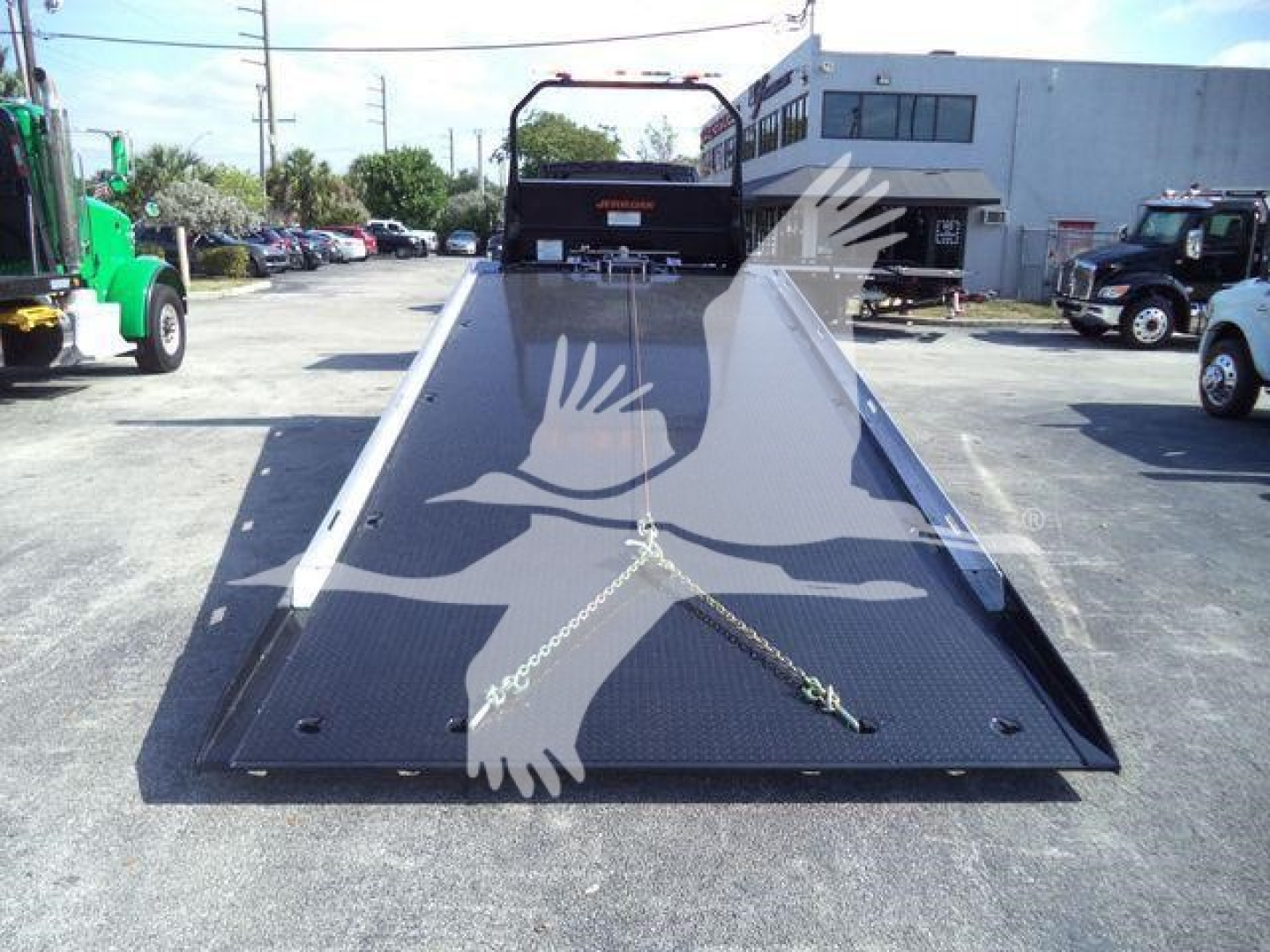 Flatbed rollback truck bed on a New 2027 International MV with front end visible in background.