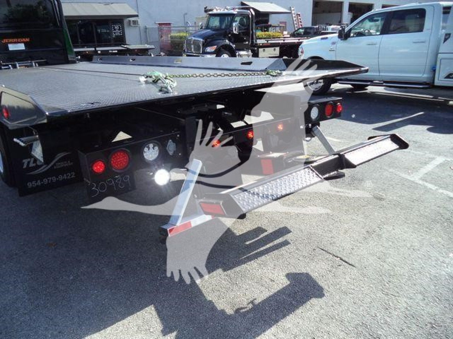 Flatbed tow truck chassis rear with hydraulic ramps and taillights showing MVEXCABBLKSHRKFM stock number