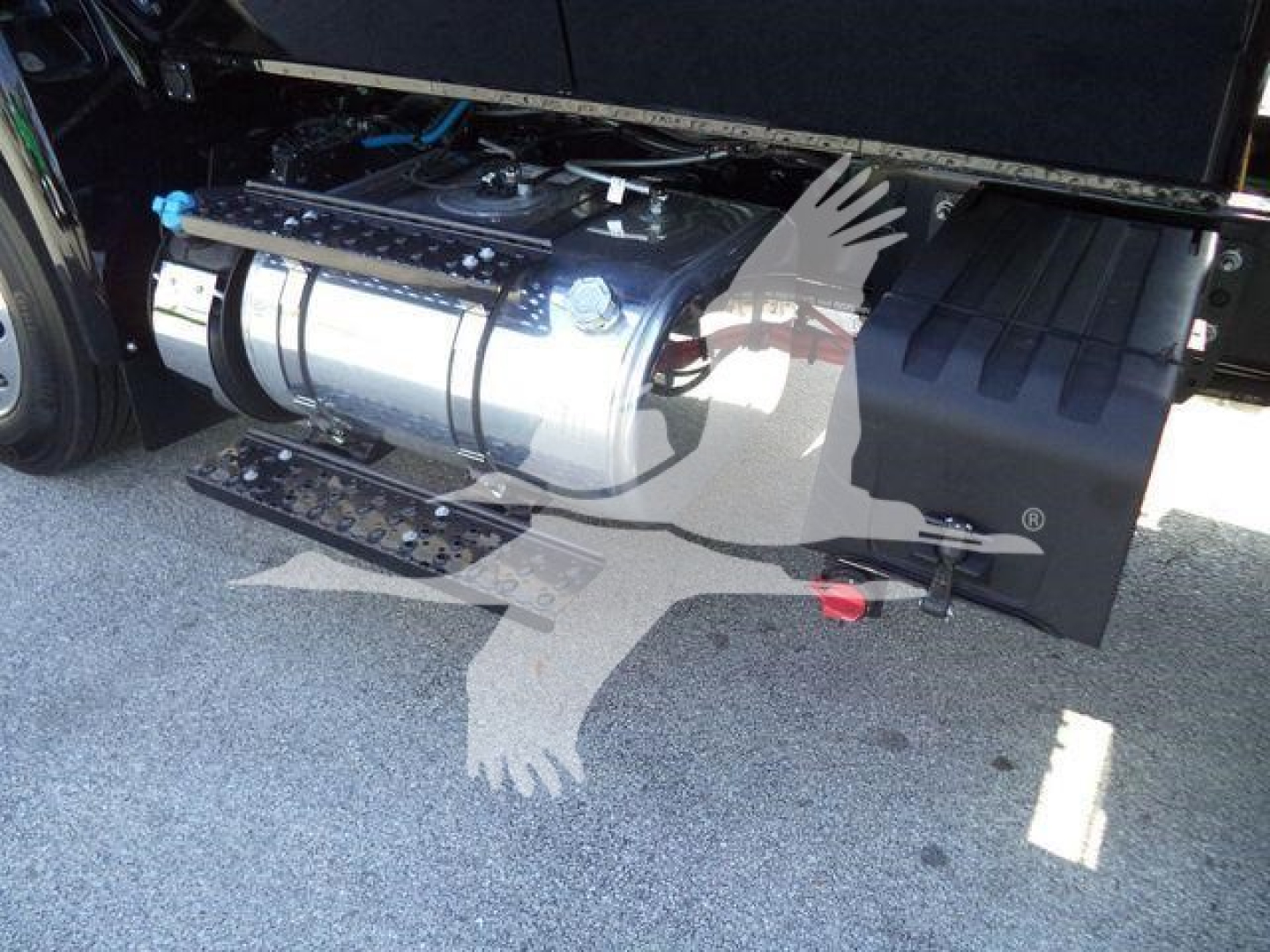 Truck fuel tank and side compartment visible under a 2027 International MV cab with rollover equipment.