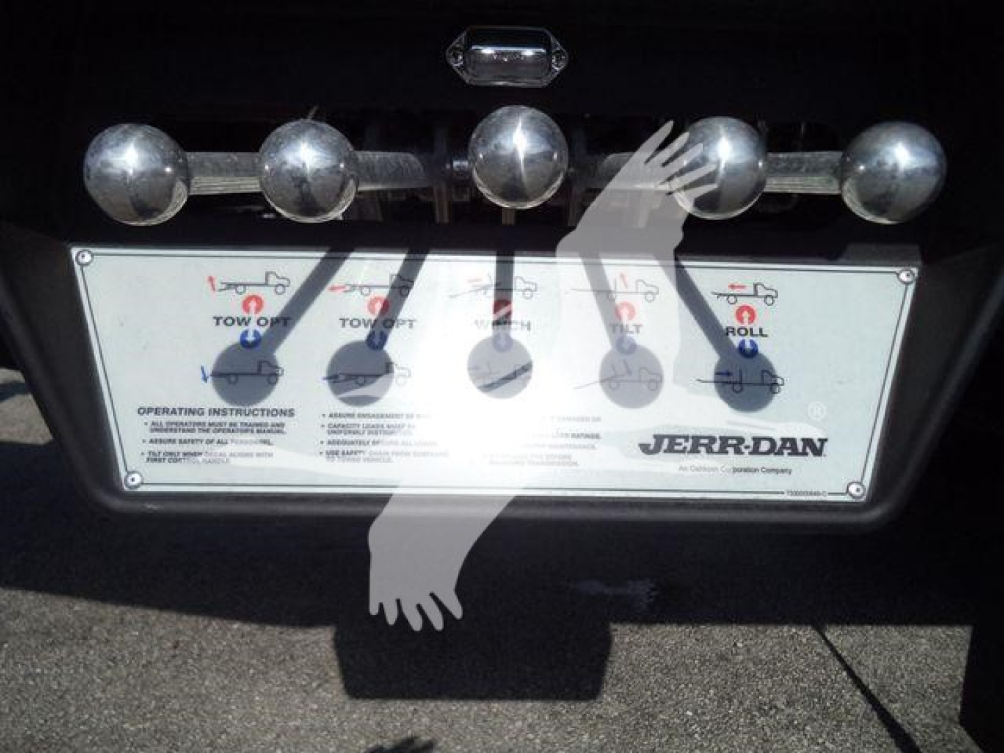 Truck rear with Jerr-Dan control panel and chrome hitch pins on bumper showing operating instructions