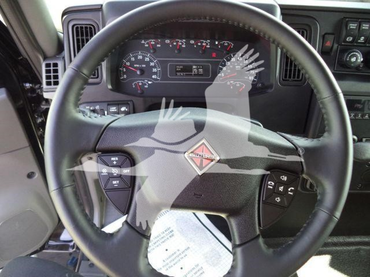 Dashboard and steering wheel of a new 2027 International MV truck, with instrument cluster and steering wheel logo visible.