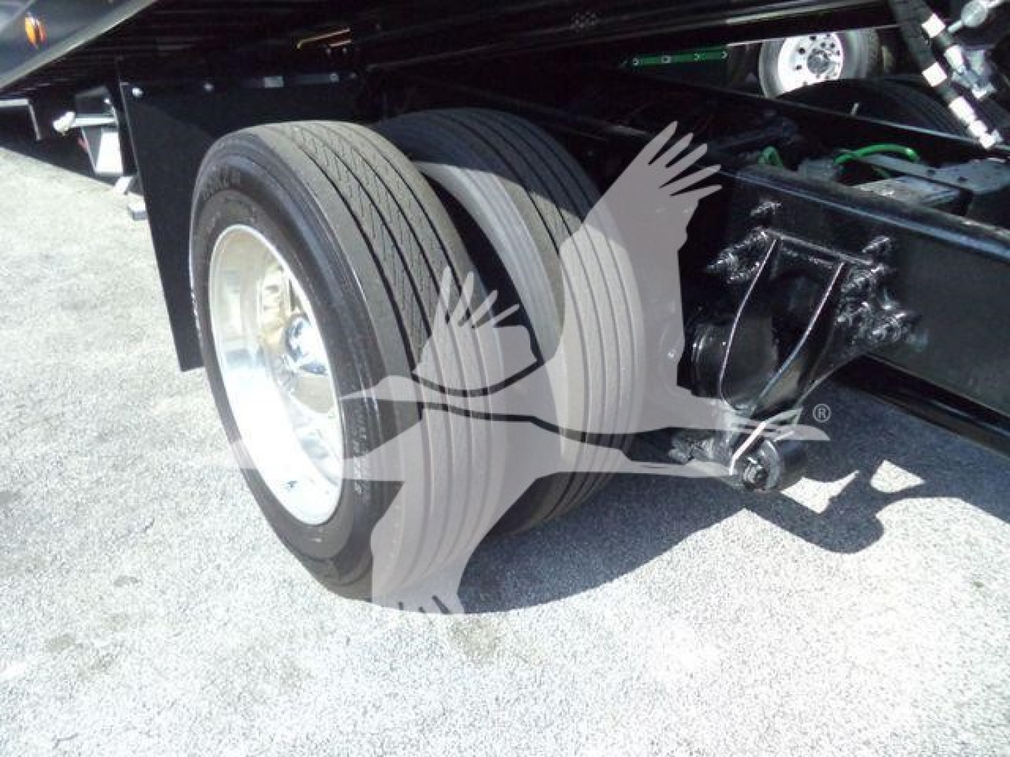 Truck rear dual wheels and suspension components visible with black chassis and green wiring.