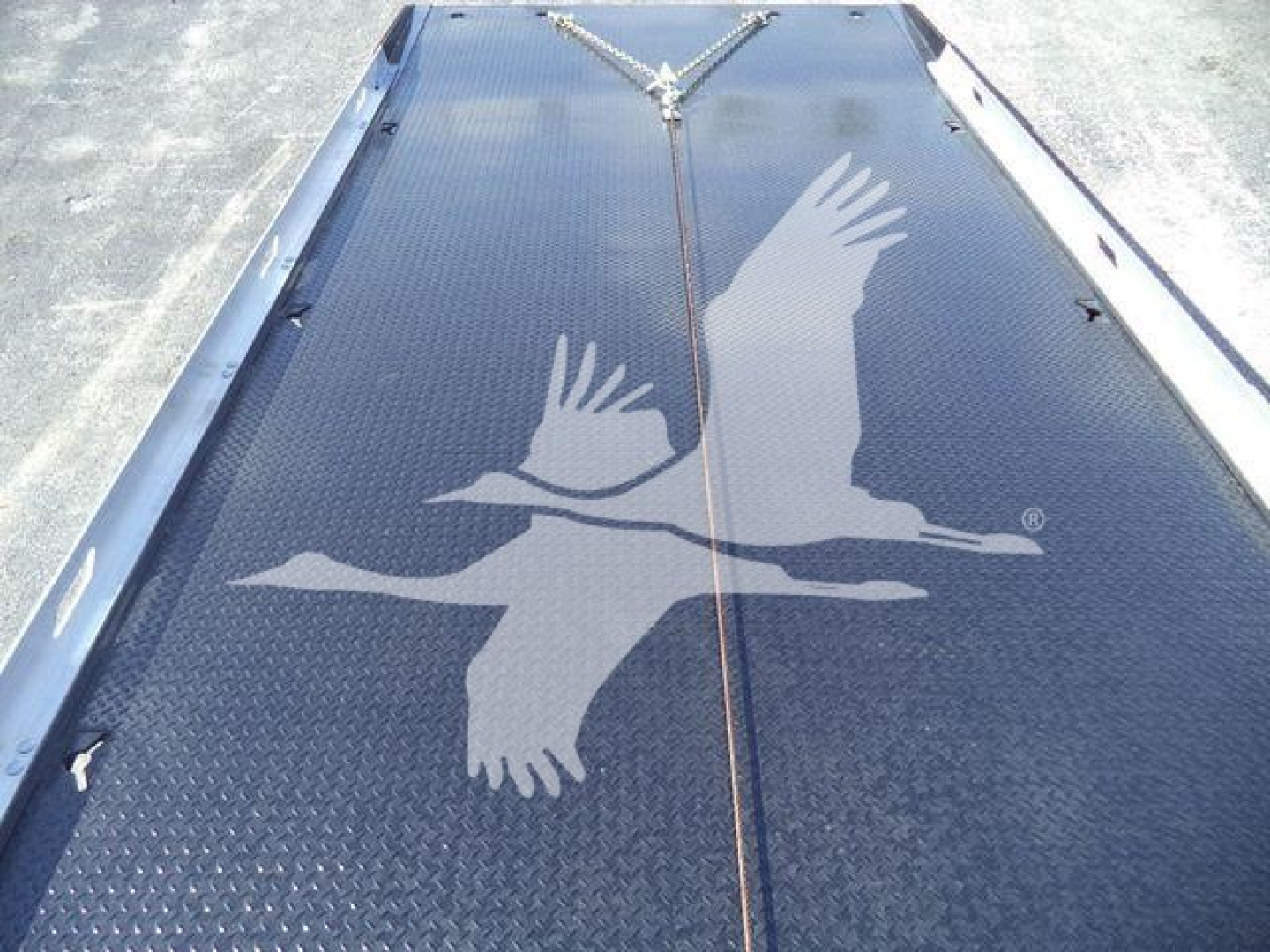 Truck bed platform showing black diamond plate with large white falcon graphic from top view.
