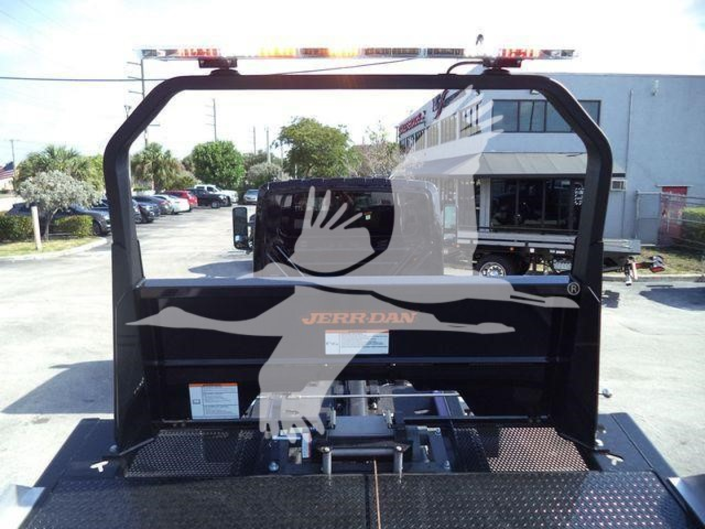 Industrial rollback truck carrier frame with Jerr-Dan branding and eagle graphic, elevated view from rear showing mounting platform and black frame.