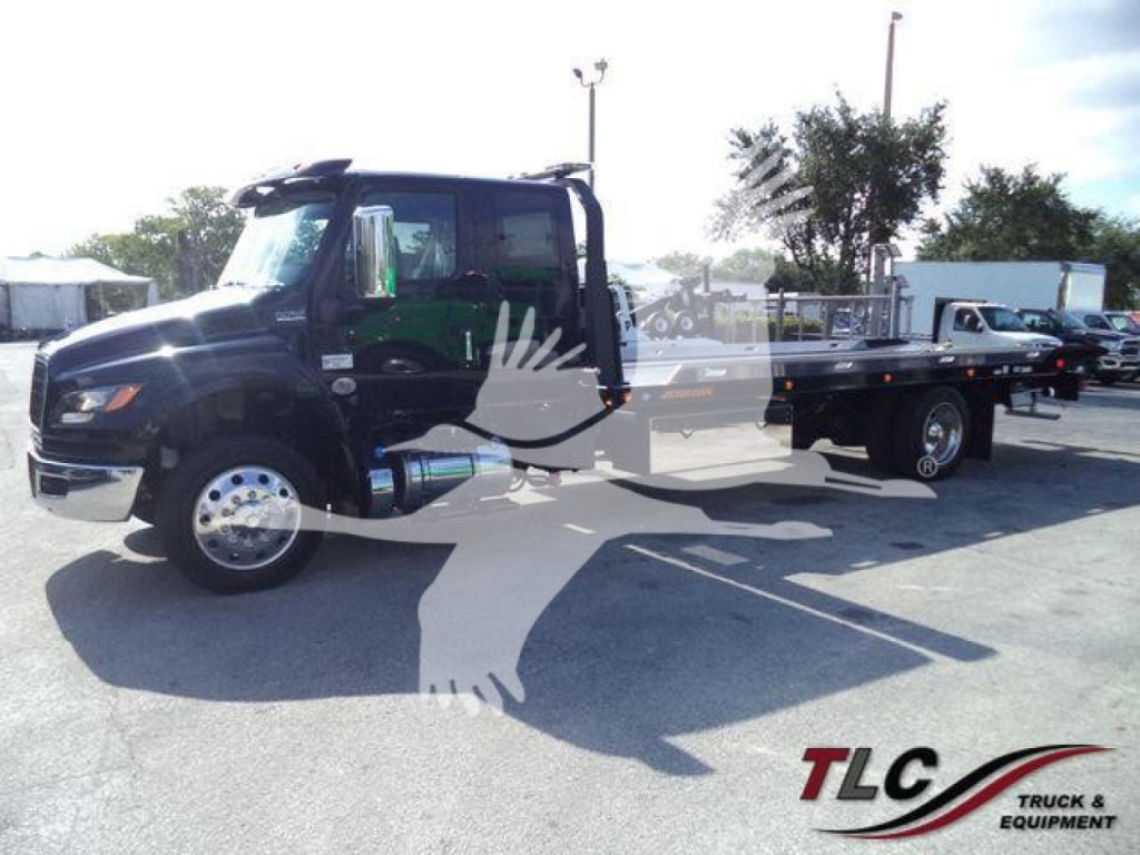 Truck cab and flatbed from a 2027 International MV rollout showing a black cab and long flatbed with branding watermark across image.