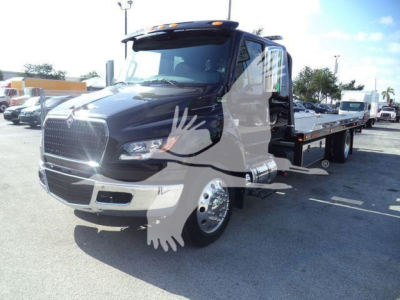 International MV rollback truck with a black body and flatbed, front view showing chrome grille and cab interior.