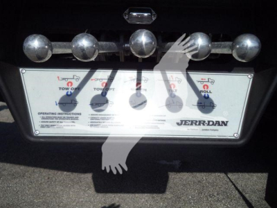 Truck rear with Jerr-Dan control panel and chrome hitch pins on bumper showing operating instructions
