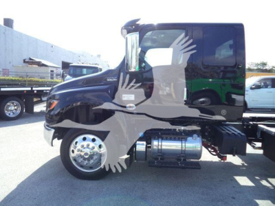 International MV truck cab side view showing clean black cab and chrome fuel tank, part of rollback fleet.