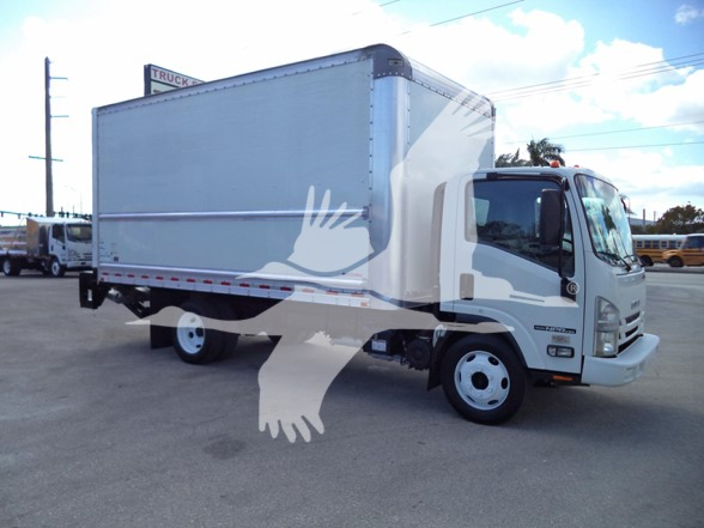 Isuzu NPR HD box truck showing cargo box and cab in a dealership lot.