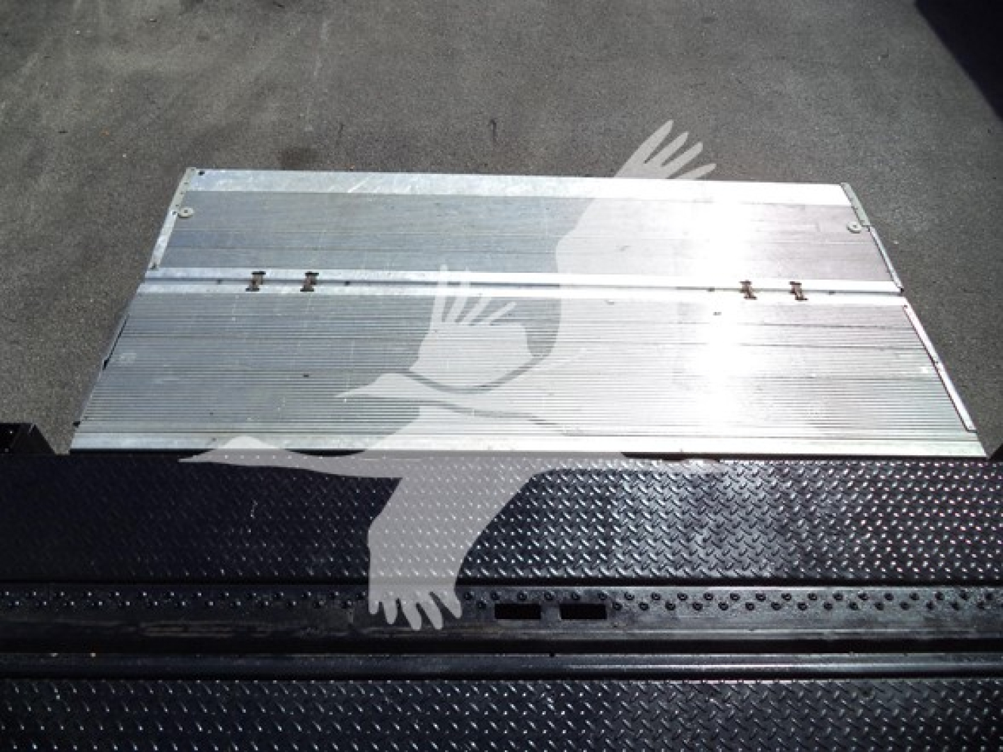 Isuzu NPR HD truck bed step/side panel with metal ribbed surface and diamond plate tread; aluminum plank on top; partial shadow of a bird graphic.