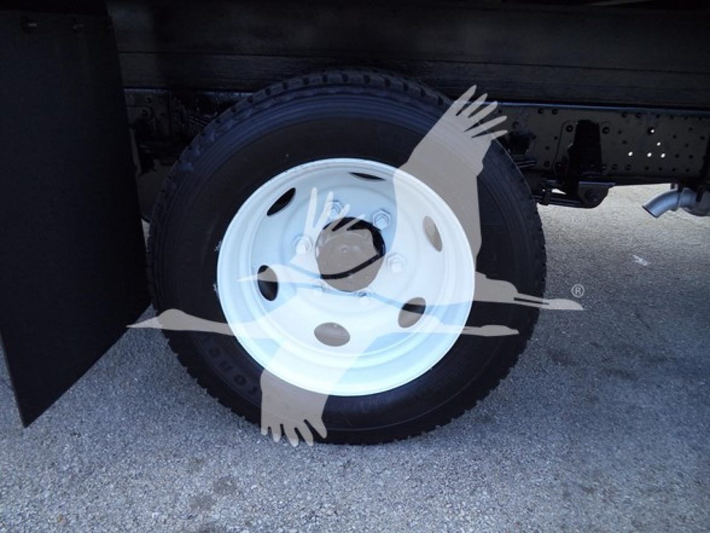 Isuzu NPR HD truck wheel and undercarriage showing spare tire and chassis; no readable labels visible on this view.