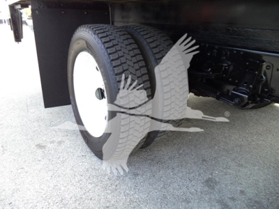 Isuzu NPR-HD truck rear wheel and dual tires under cargo box, chassis and suspension visible.