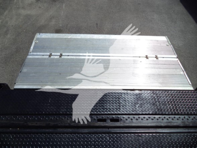 Isuzu NPR HD truck bed step/side panel with metal ribbed surface and diamond plate tread; aluminum plank on top; partial shadow of a bird graphic.