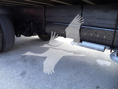 Isuzu NPR HD truck underbody view showing frame and fuel/tank area with perforated crossmember and exhaust/side shield.