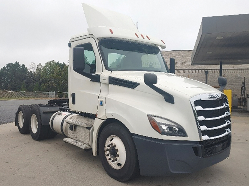 Truck cab side view of a white 2019 Freightliner Cascadia126 conventional daycab showing front grille and driver door.