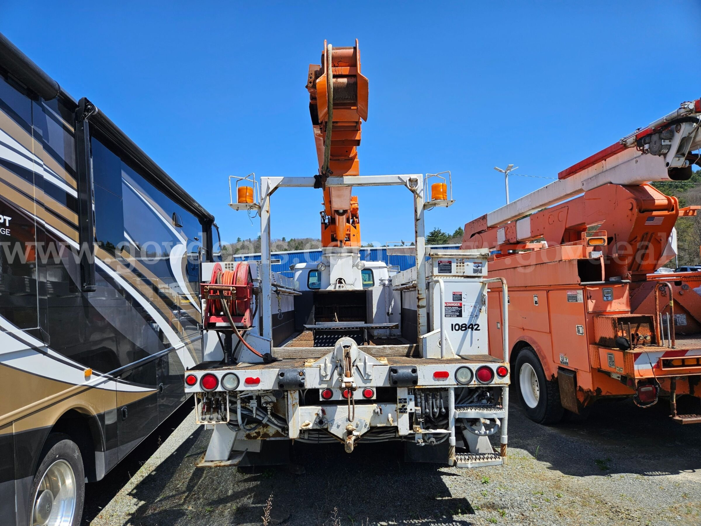 Truck bed of a 1995 International 4900 boom truck showing hydraulic lifting equipment and rear view.