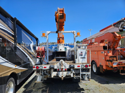 Truck bed of a 1995 International 4900 boom truck showing hydraulic lifting equipment and rear view.