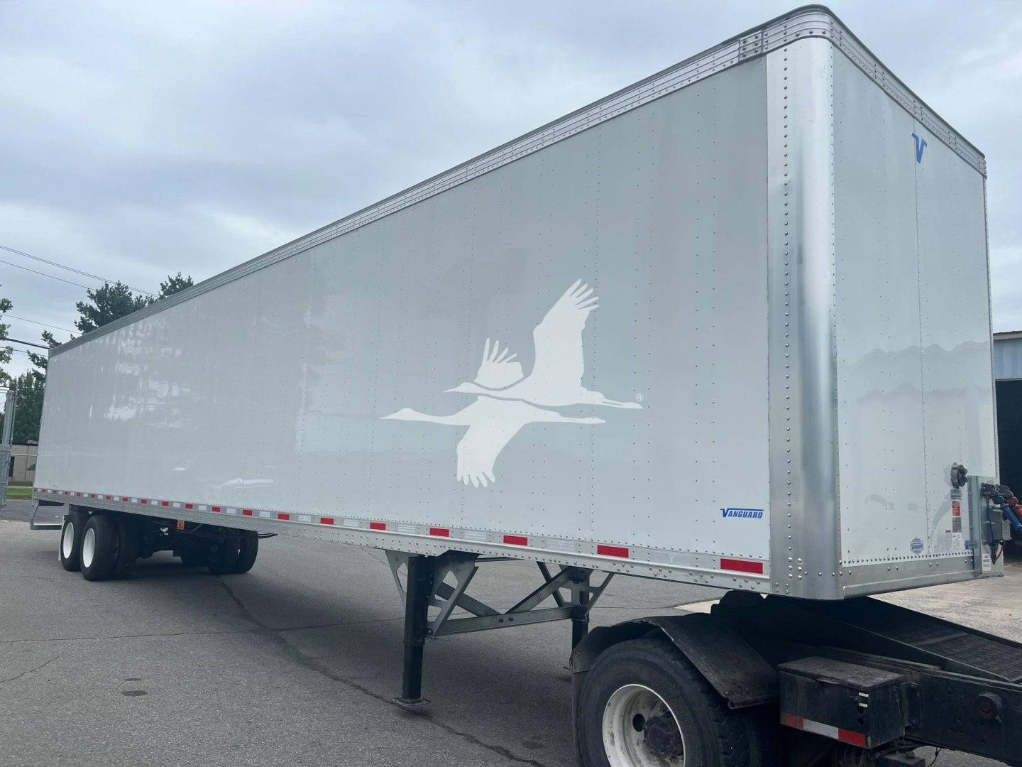 Trailer showing a Vanguard Maxcube box with a white bird logo on the side, blue Vanguard logo near the rear, and stabilizing legs at the front.